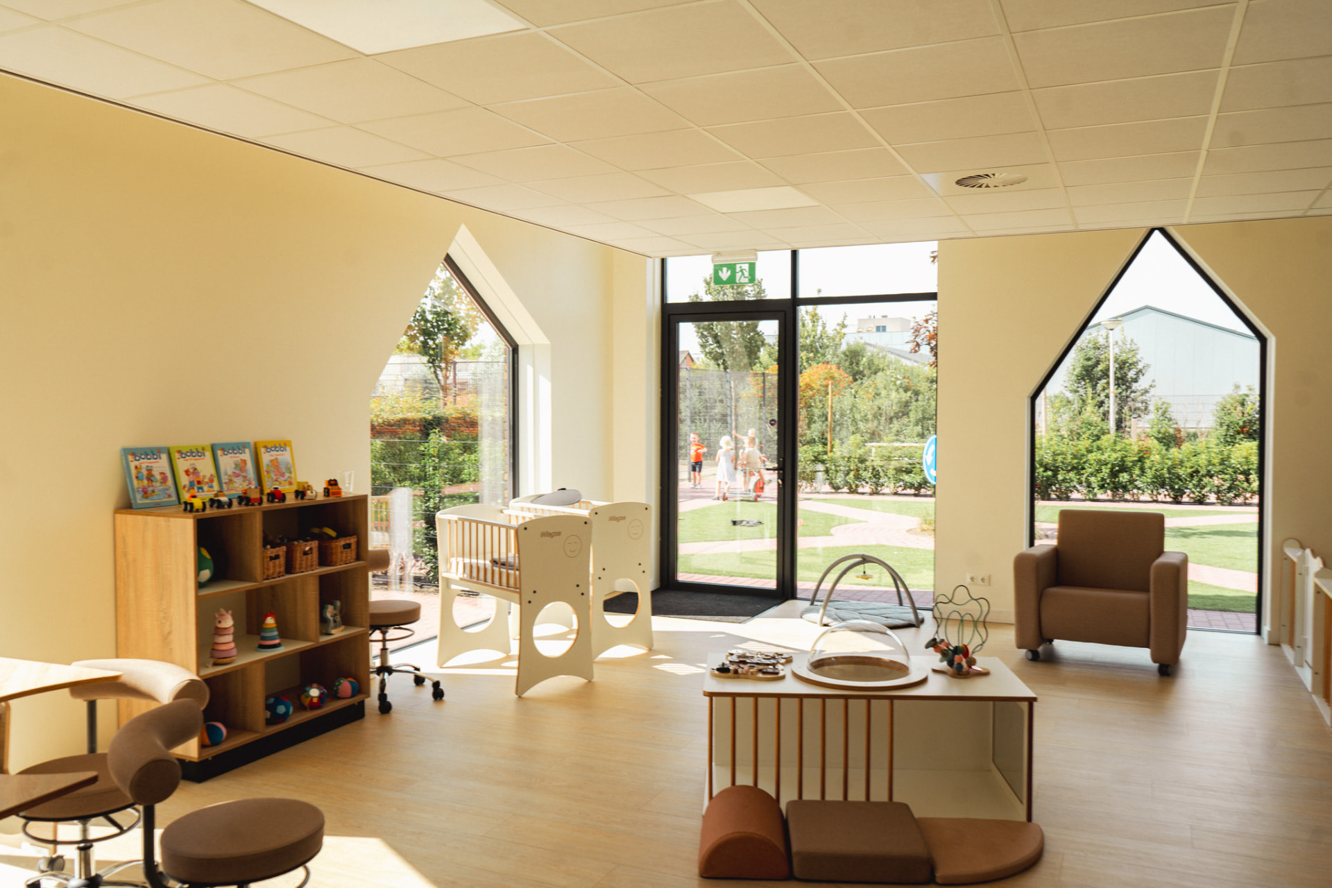 Lichte kinderkamer met zicht op de speelplaats